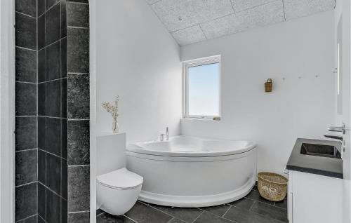 Baño blanco con aseo y lavamanos en 4 Bedroom Beautiful Home In Haderslev en Årø
