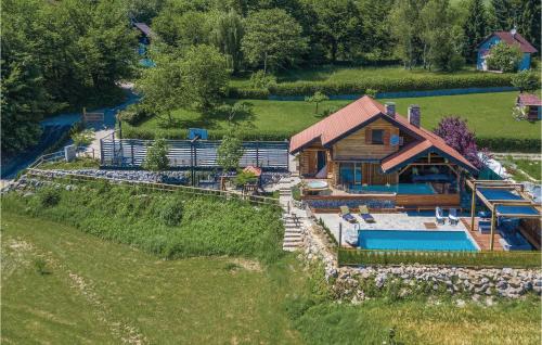 einen Luftblick auf ein Blockhaus mit einem Pool in der Unterkunft Beautiful Home In Gornji Zvecaj With Sauna in Gornji Zvečaj