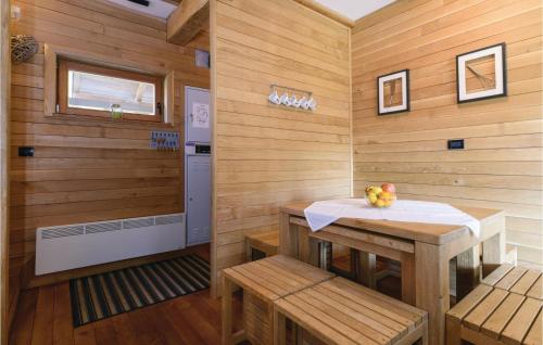 Zimmer mit einer Sauna mit einem Tisch und Bänken in der Unterkunft Beautiful Home In Gornji Zvecaj With Sauna in Gornji Zvečaj
