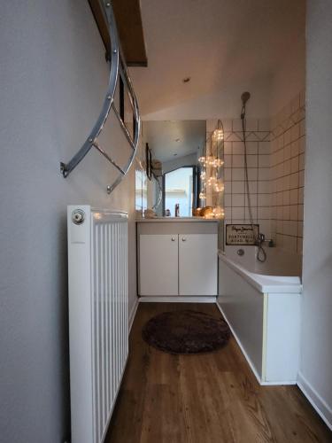 eine Küche mit einem Waschbecken und einen Flur mit einer Treppe in der Unterkunft Le Phisan in Épinal