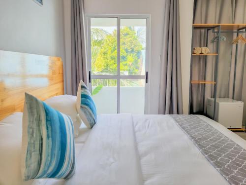 a bedroom with a white bed with a window at Hudhufas Villa in Thoddoo