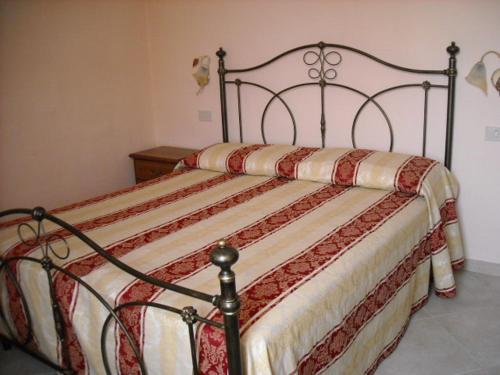 a bedroom with a bed with a red and white comforter at Appartamenti Roberta Cisanello in Pisa