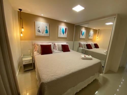 um quarto com 2 camas e um espelho grande em Apartamento Breezes do Cumbuco - TÉRREO o famoso pé na areia em Cumbuco