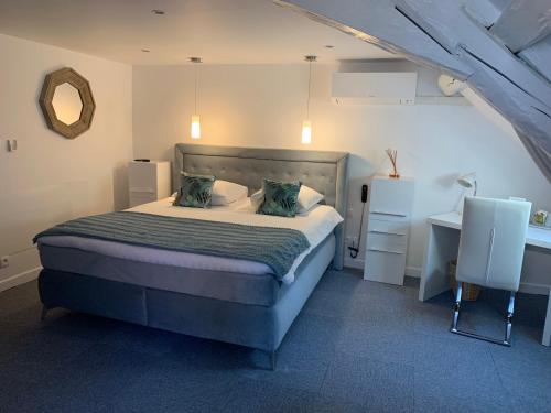 a bedroom with a bed and a desk and a sink at Hotel SPA Au Cheval Blanc in Ribeauvillé