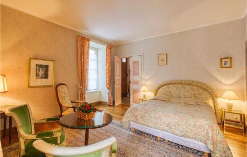a bedroom with a bed and a table and chairs at Cozy Apartment In Saint Jean Du Bruel in Saint-Jean-du-Bruel