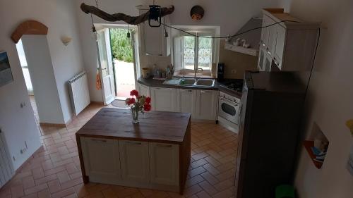 a kitchen with white cabinets and a wooden counter top at Villa Podere I Cavalieri in SantʼAnna