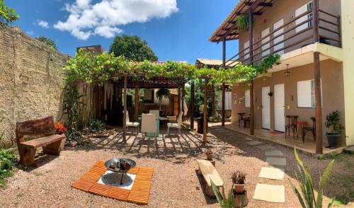 a patio with chairs and tables and a building at Villa Madeira in Alto Paraíso de Goiás