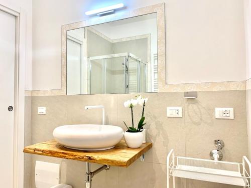 a bathroom with a white sink and a mirror at Suite Claudia in Sirmione