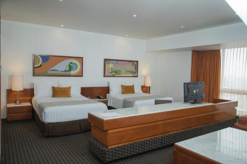 Habitación de hotel con 2 camas y TV de pantalla plana. en Sevilla Palace, en Ciudad de México