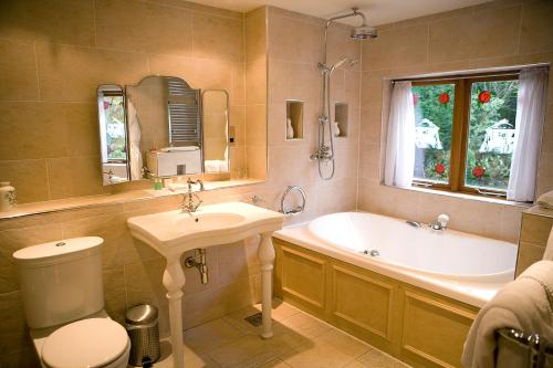 uma casa de banho com um lavatório, uma banheira e um WC. em Gibbon Bridge Hotel em Clitheroe