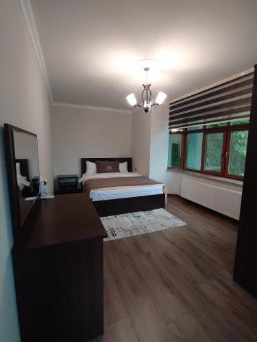 a bedroom with a bed and a desk in it at Qusar Qala Hotel in Qusar