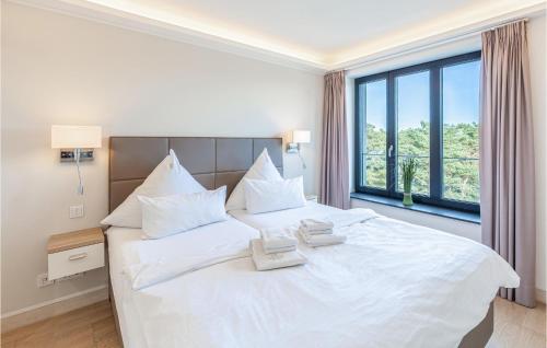 Schlafzimmer mit einem großen weißen Bett und einem Fenster in der Unterkunft Sky Suite Eden in Binz