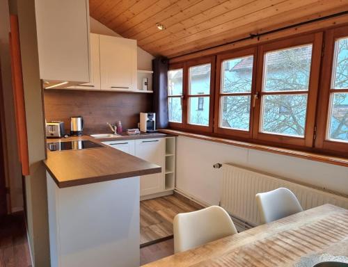 ポツダムにあるFritz Aparthotel Potsdamの白いキャビネット、テーブルと椅子付きのキッチンが備わります。