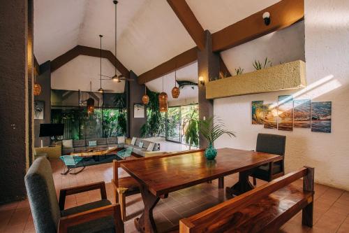 a dining room with a table and a living room at Casa Sirena in Ixtapa