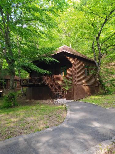 a log cabin with a staircase next to a road at Qusar Qala Hotel in Qusar
