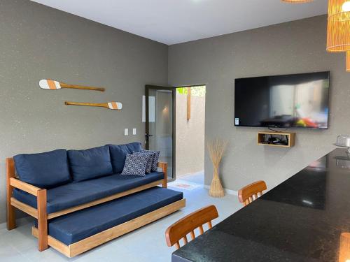 a living room with a blue couch and a tv at Nareia Casa Milagres in São Miguel dos Milagres