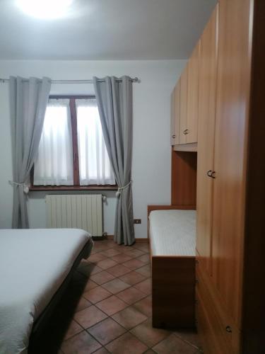a small bedroom with two beds and a window at Sweet Home Casa Vacanze "Il Bilocale" in Songavazzo