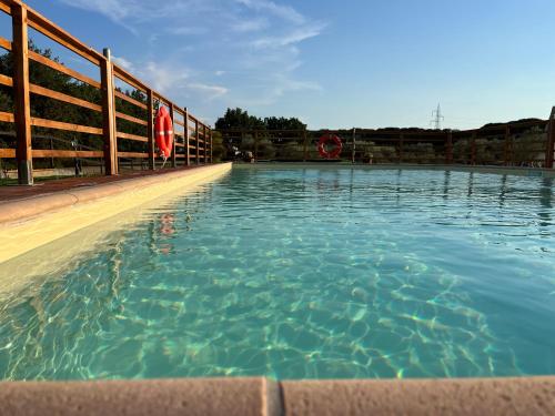 a swimming pool with blue water and a fence at Sibolla Holidays in Altopascio