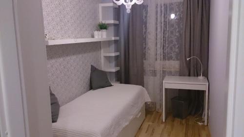 een kleine slaapkamer met een klein bed en een raam bij 1 Bedroom City Center Apartment in Katowice