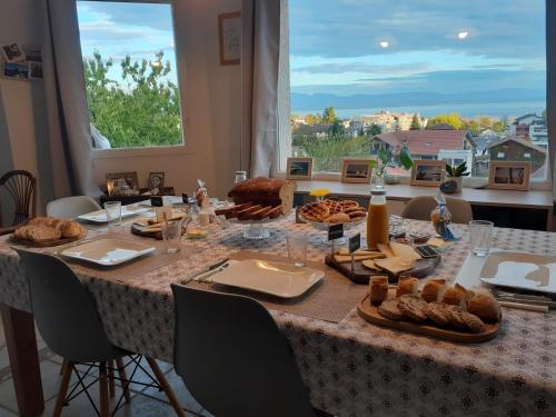 una mesa con comida en ella con una gran ventana en Entre Alpes et Léman, en Publier