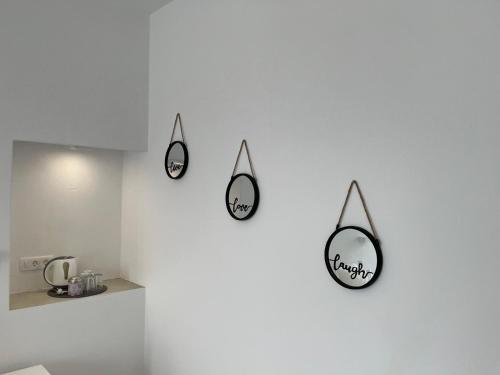 three mirrors hanging on a wall in a kitchen at Firaxenia rooms in Fira