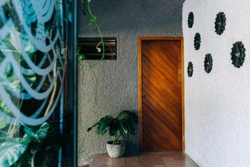 a wooden door with a potted plant next to it at Casa Sirena in Ixtapa