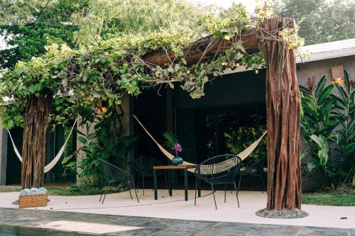 a pergola with a hammock and a table and chairs at Casa Sirena in Ixtapa