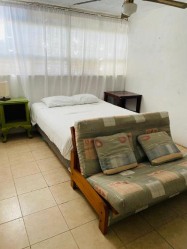 a bedroom with a bed and a couch in it at Casa Alfenapa a pie del lago y pet friendly in Tequesquitengo