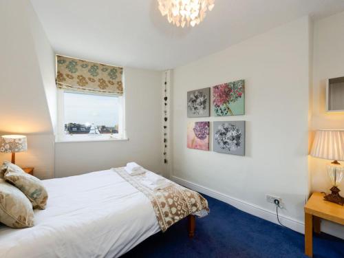 a bedroom with a white bed and a window at Bass Rock View in North Berwick