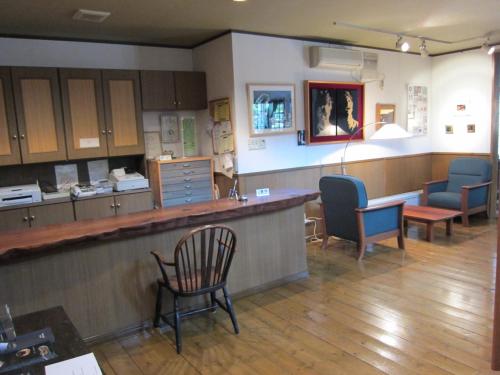 a large waiting room with chairs and a bar at Kunsthaus in Biei