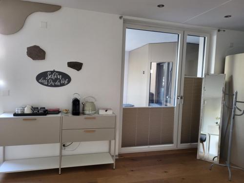 a kitchen with a white dresser and a sliding glass door at Oase zum SEIN in Spiez