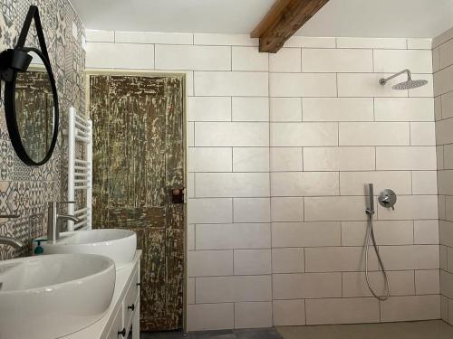 a bathroom with a shower and a sink and a mirror at Casa do Tio Plácido in Valezim