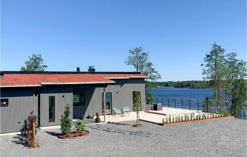 a house with a patio and a body of water at Lovely Home In Skillingaryd With Sauna in Skillingaryd