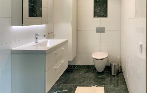 a white bathroom with a sink and a toilet at Lovely Home In Skillingaryd With Sauna in Skillingaryd