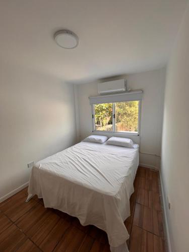 1 dormitorio con cama blanca y ventana en DPTO MODERNO AMOBLADO TEMPORARIO PARANÁ, Entre Ríos en Paraná