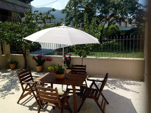 a wooden table with chairs and an umbrella at Maza House in Stavros