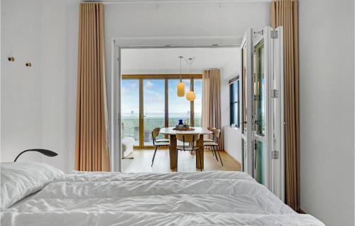 2 Bedroom Gorgeous Apartment In Kerteminde في كيرتيمايند: غرفة نوم بسرير وطاولة مطلة