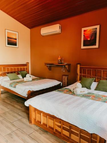 two beds in a room with orange walls at Hotel Boutique Meraki in Caldera