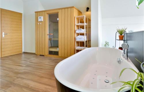 y baño con bañera y suelo de madera. en Amazing Home In Selnica With Kitchen en Selnica