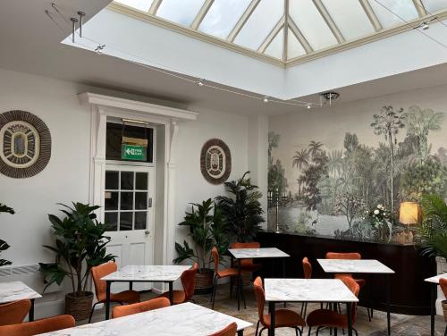 a dining room with tables and chairs and a skylight at The Warwick Arms Hotel in Warwick