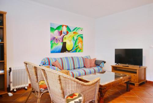 uma sala de estar com um sofá e uma mesa em Carlos House - Baleal beach, Sunny balcony, Shared pool no Baleal