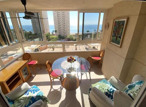 Pokój ze stołem i krzesłami oraz widokiem na ocean w obiekcie Alicante Apartamento en la Playa Muchavista-San Juan - Marluma frente al Mar w mieście La Venteta