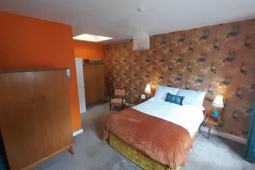 a bedroom with a bed and a wall with birds on it at Quirky mid century themed holiday home in Shepton Mallet