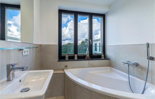 a large white bath tub in a bathroom with windows at Skysuite in Binz