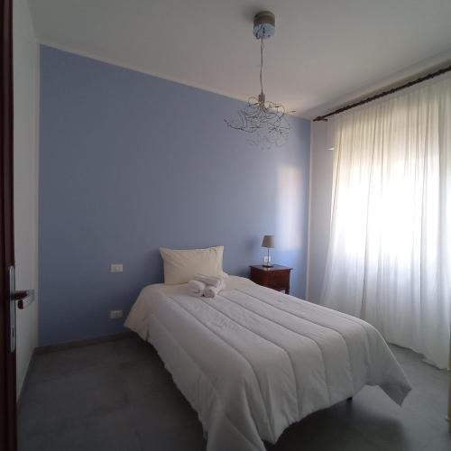 a bedroom with a large white bed with a blue wall at Casa Minù in Viareggio