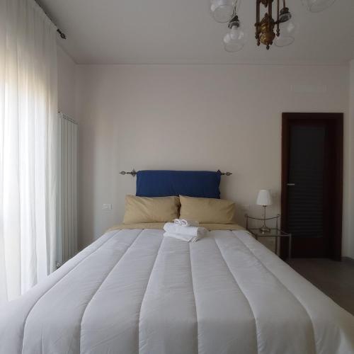 a large white bed with a blue headboard in a bedroom at Casa Minù in Viareggio