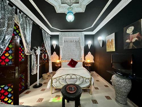 a bedroom with a bed and a tv in it at Riad Mogador in Meknès