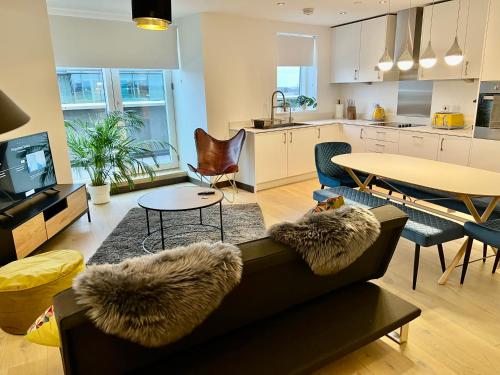 a living room with a couch and a table at Walnut Tree Penthouse Next to Train Station in Cambridge