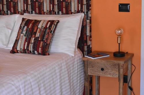 a bed with a pillow and a side table with a lamp at Cascina Tre Botti in Agliano Terme