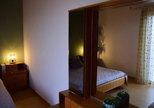 - une chambre avec un miroir et un lit dans une pièce dans l'établissement Affordable vintage apartment near Fiscardo & Assos, à Fiskardho